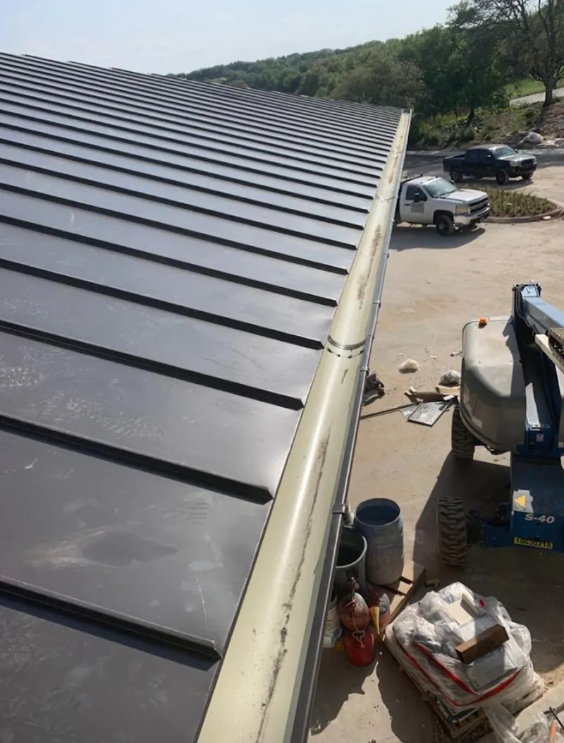 Standing seam panel and gutter detail on a metal roofing jobsite in Laurens